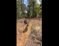 Boy rides dirt bike up side of hill 