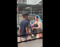 Person with rainbow veil walking on street looking confused 