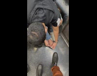 Man puts plaster on pinky toe inside the train