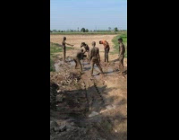 Men covered in mud plays with puddle