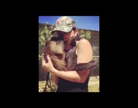 Girl holds brown monkey chimpanzee in arms 