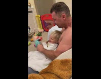 Guy shakes toy in front of baby 