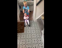 Kid pushes baby in toy push chair