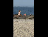 Woman bikini sit pose on rock beach