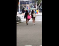 Two women carry toilet paper rolls on head