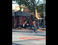 Biker balances with trashcan on head with leg out 
