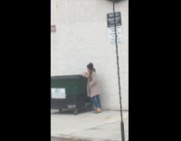 Woman brown coat lean garbage can Christmas