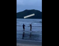 Black bathing suit girl lifts arms up 