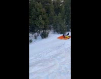 Friends ride orange inflatable raft down mountain 