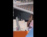 Woman white top dances top of stairs