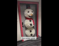 Girl builds snowman on apartment door for decoration