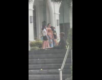 Group of friends poses while a kid watches them