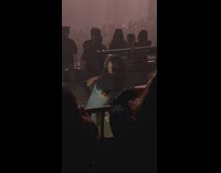 Woman dances on a concert in front of phone with flash
