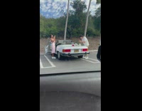 Man eat burger on white convertible car