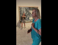 Woman grey skirt take selfie with painting