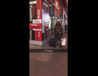 Shirtless buff guy in red skull demon mask holds bucket with speakers and stands still on sidewalk