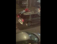 Man in red sweater laying down on moving car