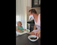 Baby watches guy with bird mask eat 
