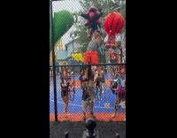 People steal large plushy prizes on fence