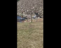 Guy stand unstable log rocky lake windy