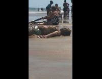 Man lie down on the beach shore with mud on him