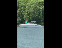 Woman blue dress stand front boat lake