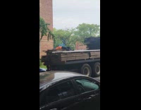 Man lay on back of truck carrying wood