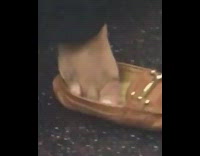 Girl takes foot out of brown shoe 