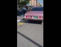 Pink vintage car drives on the street