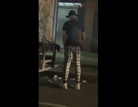 Black shirt guy pees white truck street