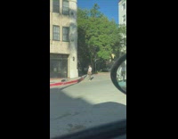 Woman in white crop top camouflage pants tiktok on the sidewalk