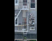 Guy repairs outside of window above high level 