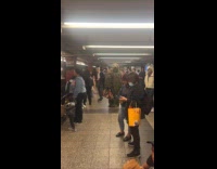 Person wears ghillie suit at train station