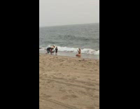 Gold bathing suit girl crawls dances beach 