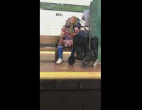 Guy in cultural outfit sits on subway bench 