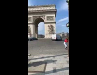 Girl wearing red jacket dances by arch 