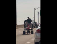 Man wheelie stunt with ATV on expressway 