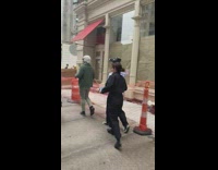 Guy in wig waves at filmer 