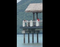 Guy red shirt dance hut roof beach
