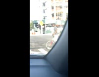 Guy rides red bicycle balances ball head