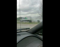 FedEx truck drives at road smoking packages