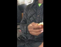 Man takes out chicken nugget from jacket pocket and eats it on subway train