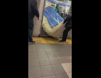 Men Unload Wrapped Couch from Subway Train