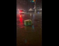 Green amazon delivery box float on gutter flood
