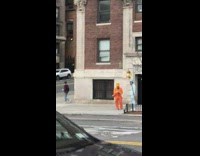 two guys in orange and blue suits on the street