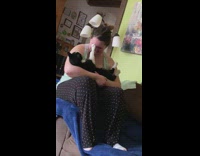 Girl cradles black white cat paw face 