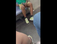 Guy riding subway wears kermit sneakers 