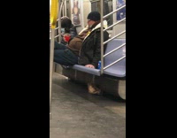 Guy drinks from wine glass on subway 