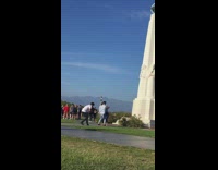 2 dancers do a partner dance for video in front of statue
