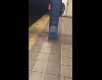 Man peeing behind a metal pillar at subway station